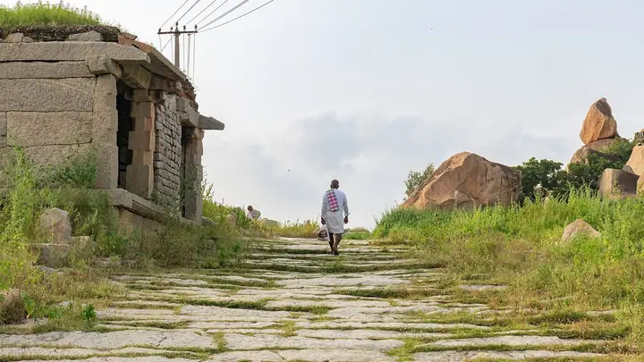 Stariji muškarac hoda kamenim putem uzbrdo