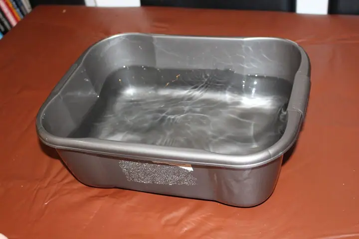 Plastični lavor napunjen čistom vodom na stolu